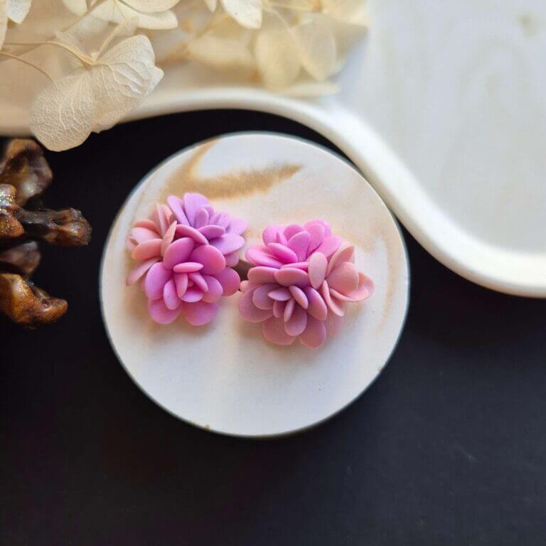 Cercei din lut polimeric, buchet cu 3 flori in nuante de roz asezati pe un suport ceramic. Se pot observa detaliile florilor