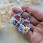 cercei din lut polimeric si cristale, in nuante de albastru si crem-vanilie fotografiate peo mana pentru a se vedea dimensiunea lor