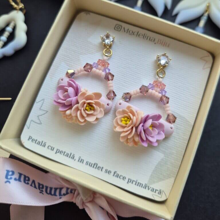 cercei din lut polimeric si cristale, in nuante pale de roz si mov fotografiate in cutia cu care ajung la destinatar