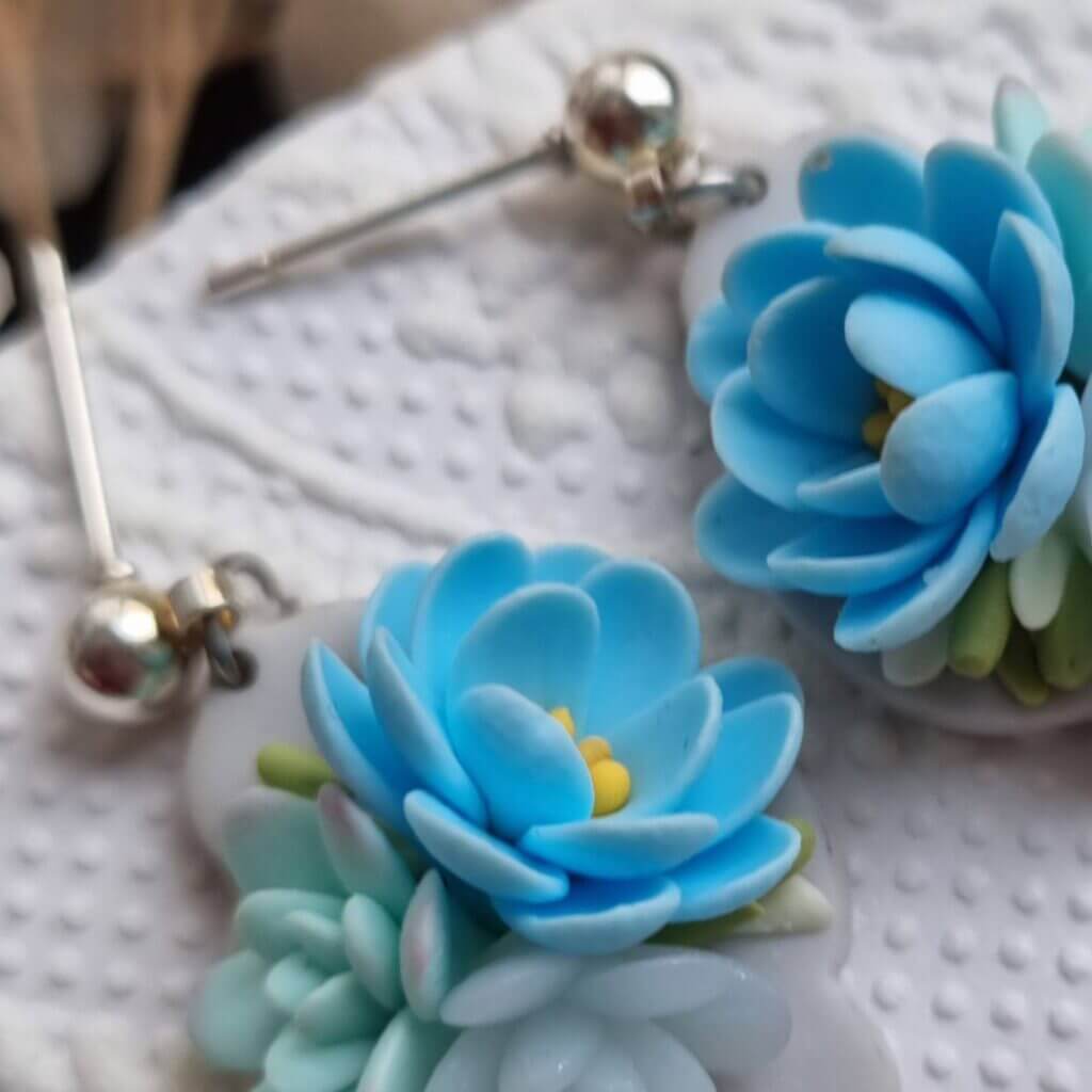 detaliu cercei lut polimeric cu buchet de flori albastre tortite cercei otel inoxidabil