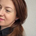 Femeie purtand o pereche de cercei lucrați manual în formă de plante suculente, de culoare mov violet. Accesorii boho-chic